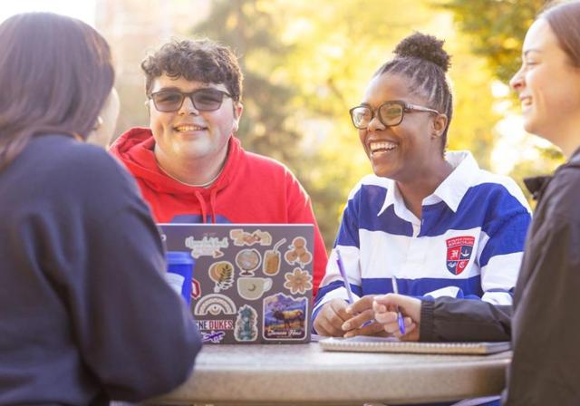 Student sitting at round table having a pleasant conversation.
