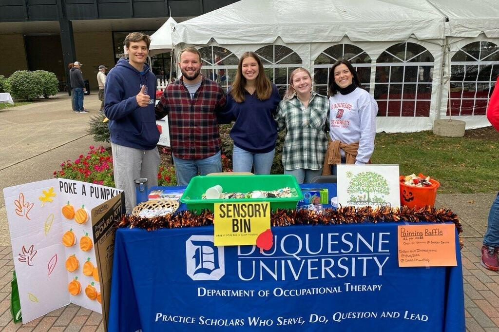 OT students behind a table for COTAD