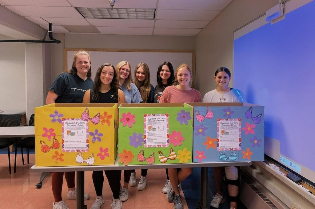 OT students stand behind boxes they created for PTE fundraiser.