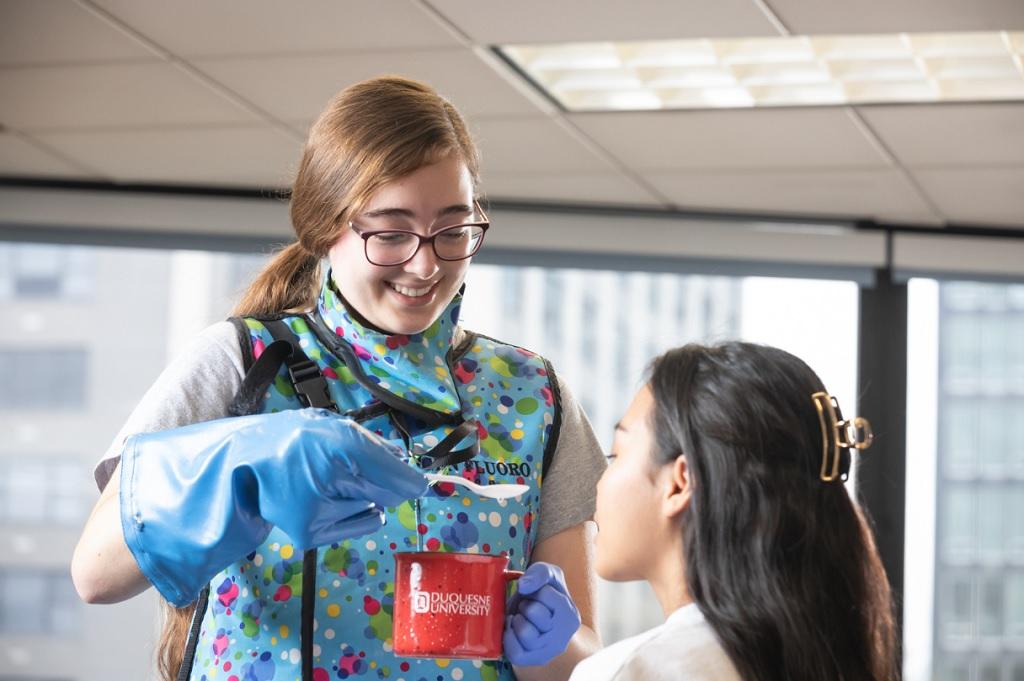 SLP students practicing swallowing techniques.