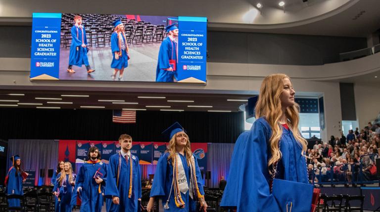 Graduates walking to receive diplomas.