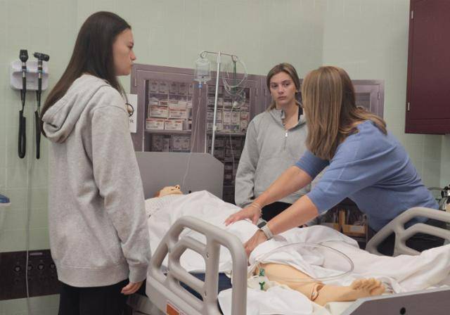 OT Student in Simulation Lab practicing moving a patient.