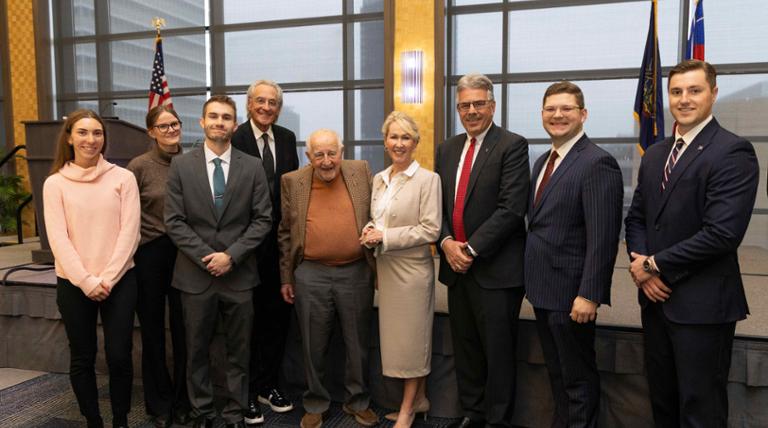 Eight people standing and smiling with Judge Guido Calabresi