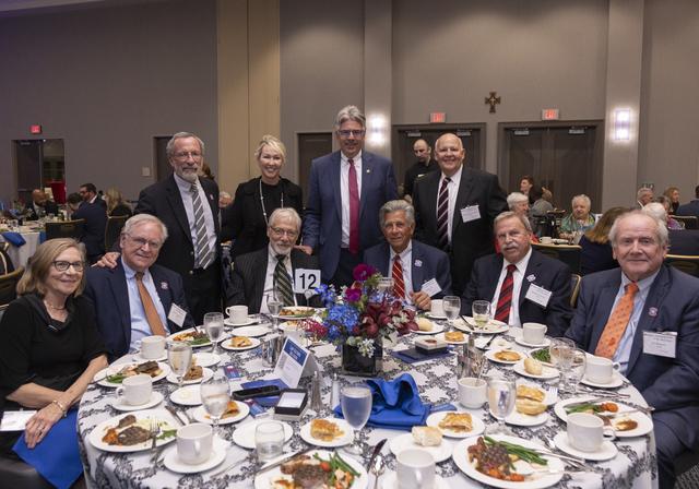 Alumni gathered around a table with President Gormley and Dean Barton during dinner