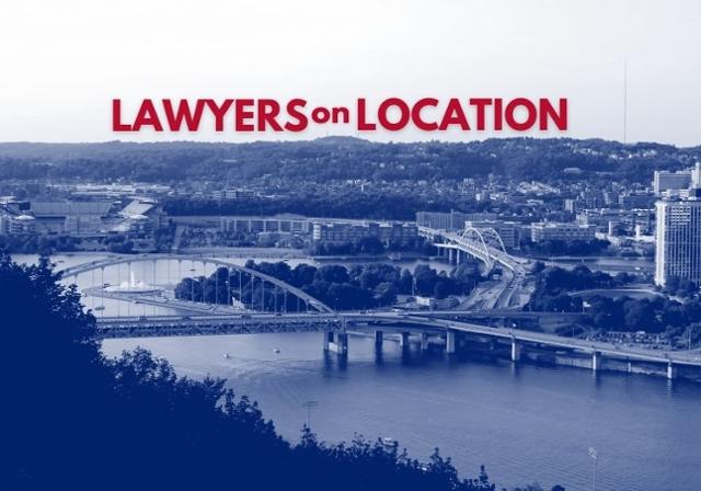 Picture of the City of Pittsburgh depicting a bridge and some buildings with a tree-covered hillside in the background.  The words Lawyers on Location appear in red at the top of the image.