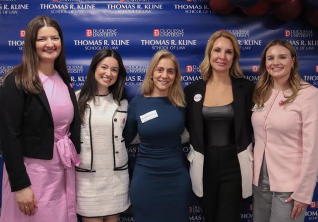 Five professional women standing in front of a large blue sign that reads Thomas R. Kline School of Law. 