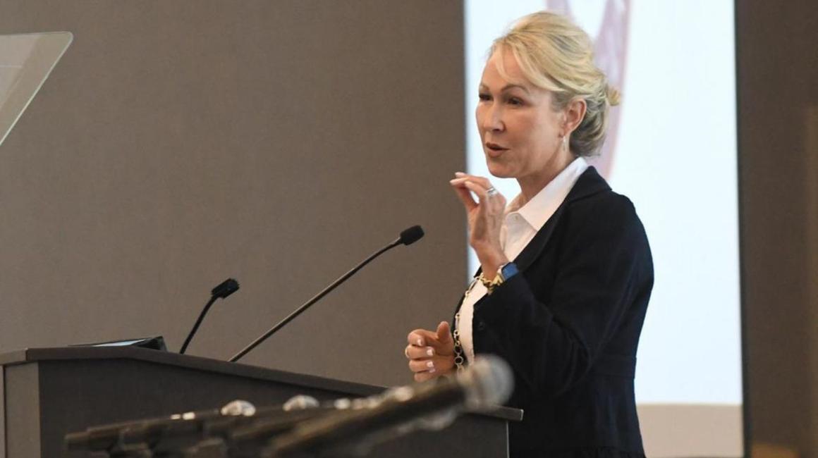 Dean April Barton lecturing from a podium