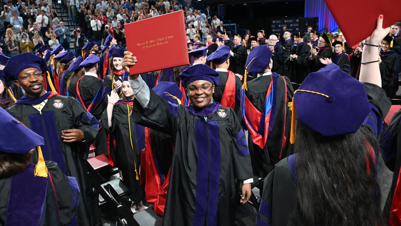 Graduates holding diplomas