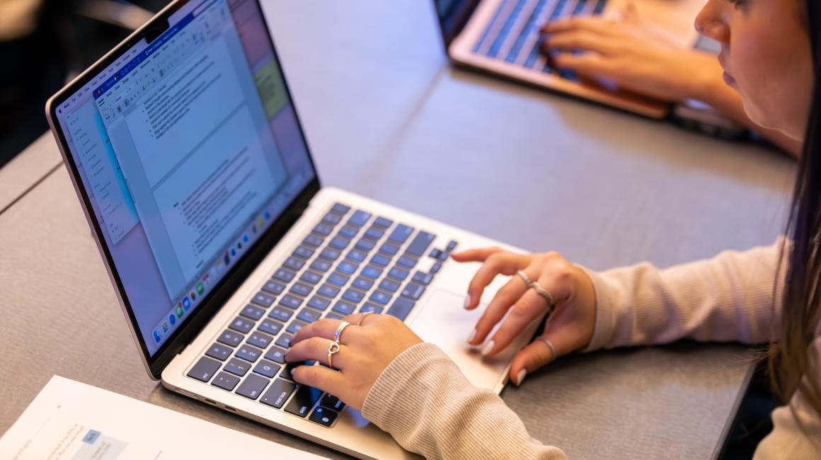 student typing on computer