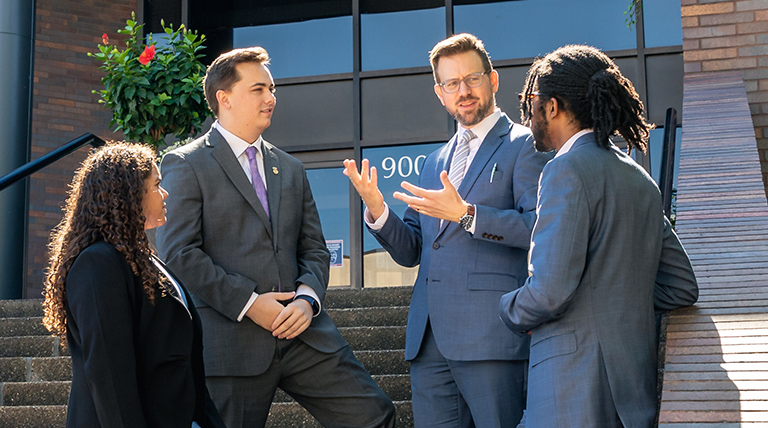 Group of law students talking out the law school building.