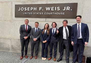 Six people standing outside of courthouse.