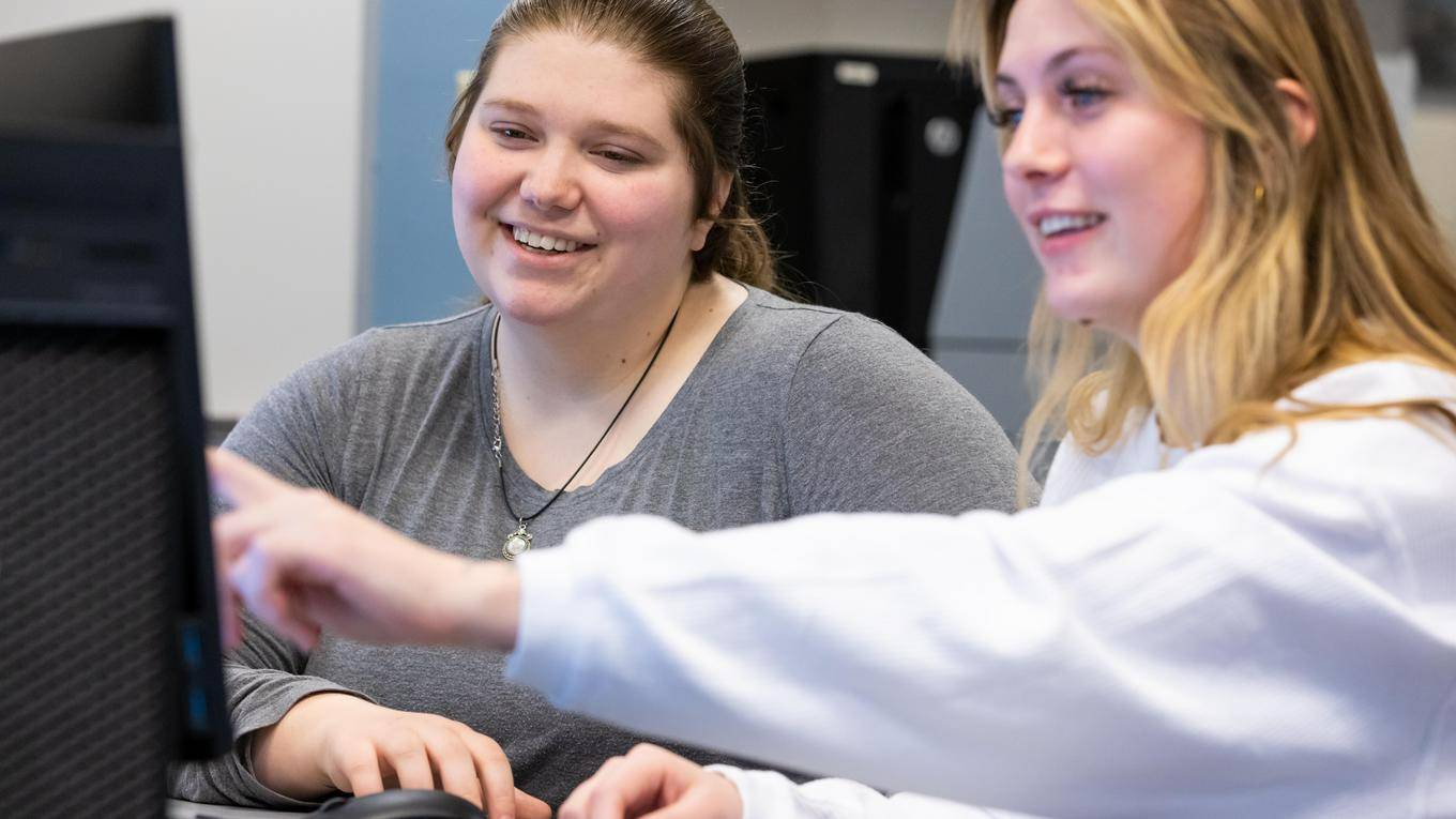 Two students examining a computer screen