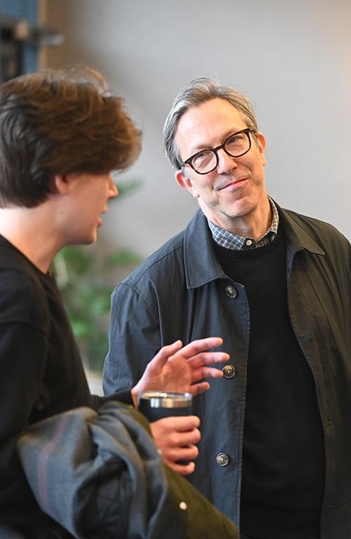 John Fried speaks with student after an author lecture.