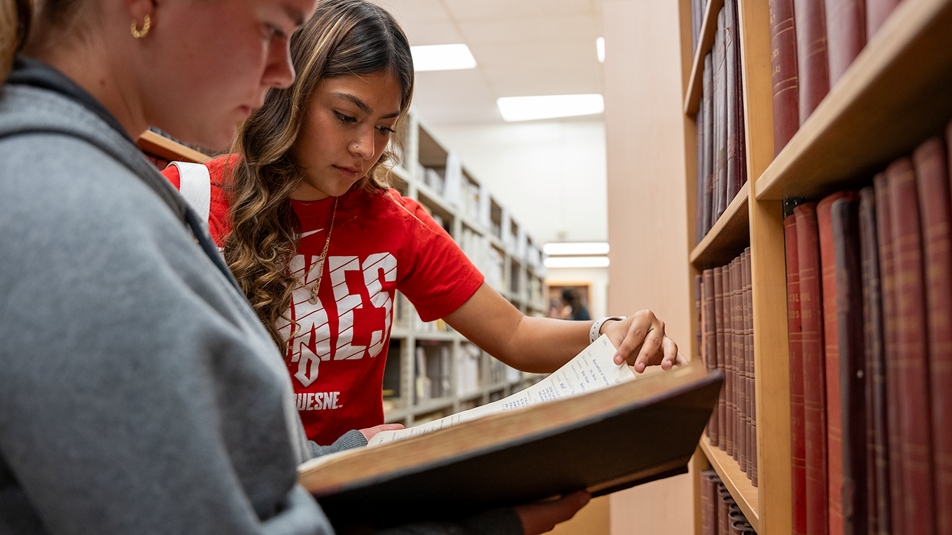 Student reading book in archives.