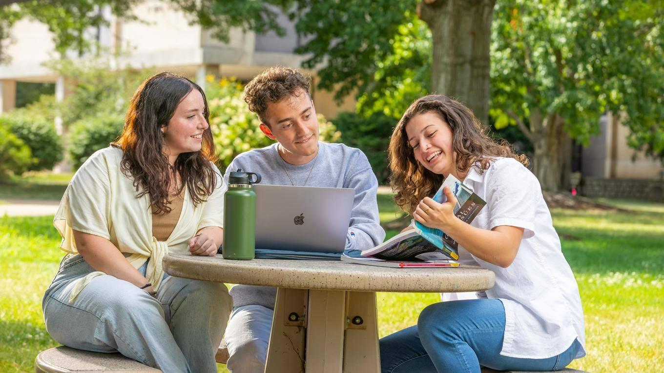 Three students studying outside on Duquesne's campus