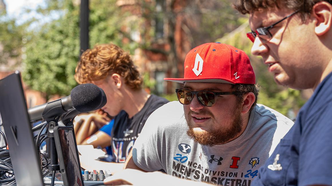 Two Duquesne Student Radio students broadcast live outside during an event.