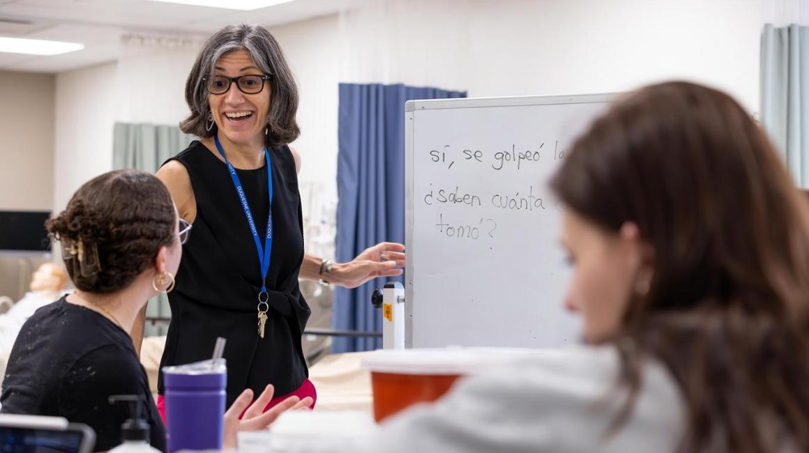Female professor teaching spanish to two female students