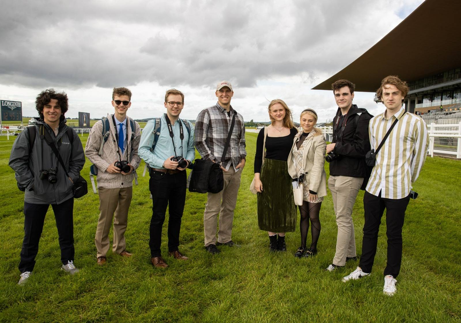 Students standing with Bob Healy on a field with their cameras