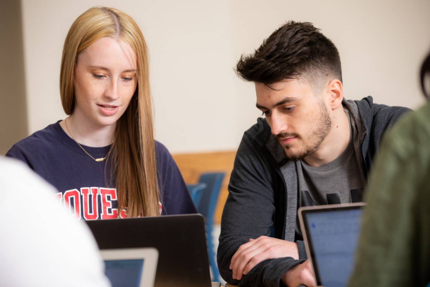 two students looking at a laptop in the classroom