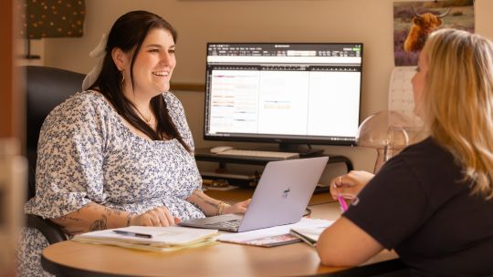 Sage Rios advises a student in her office.