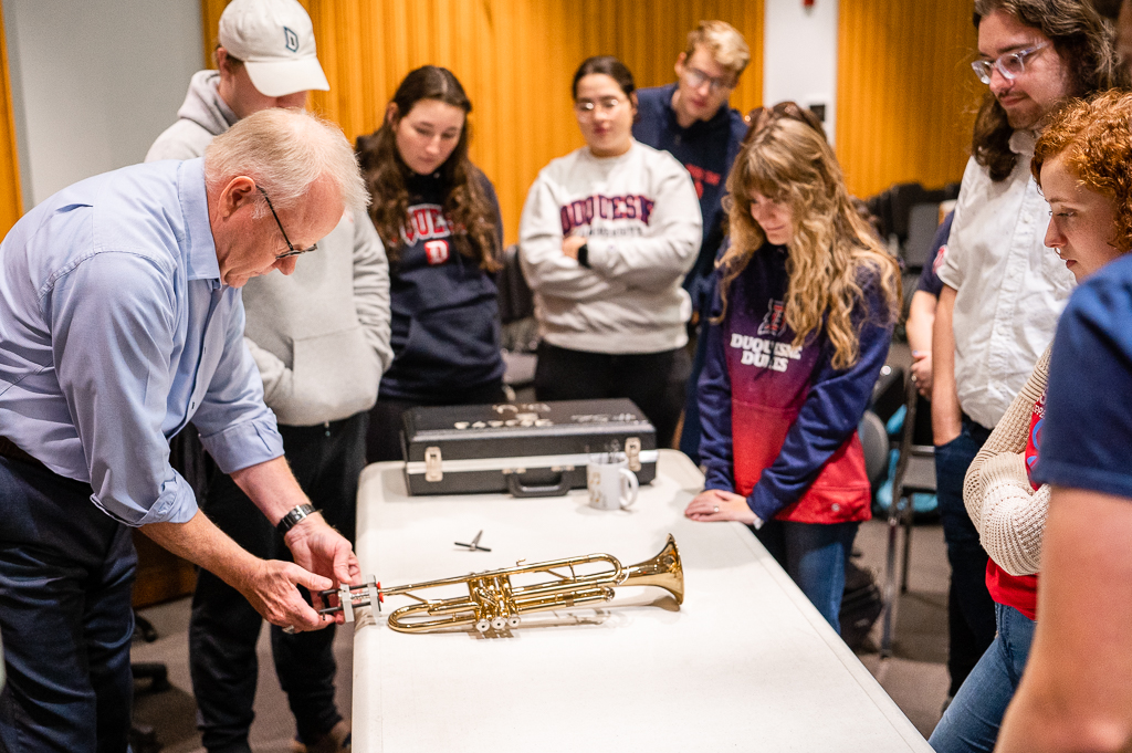 A professor demonstrates how to use a mouthpiece puller to students.