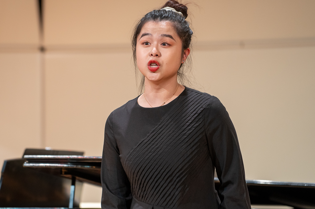 A student sings on stage.