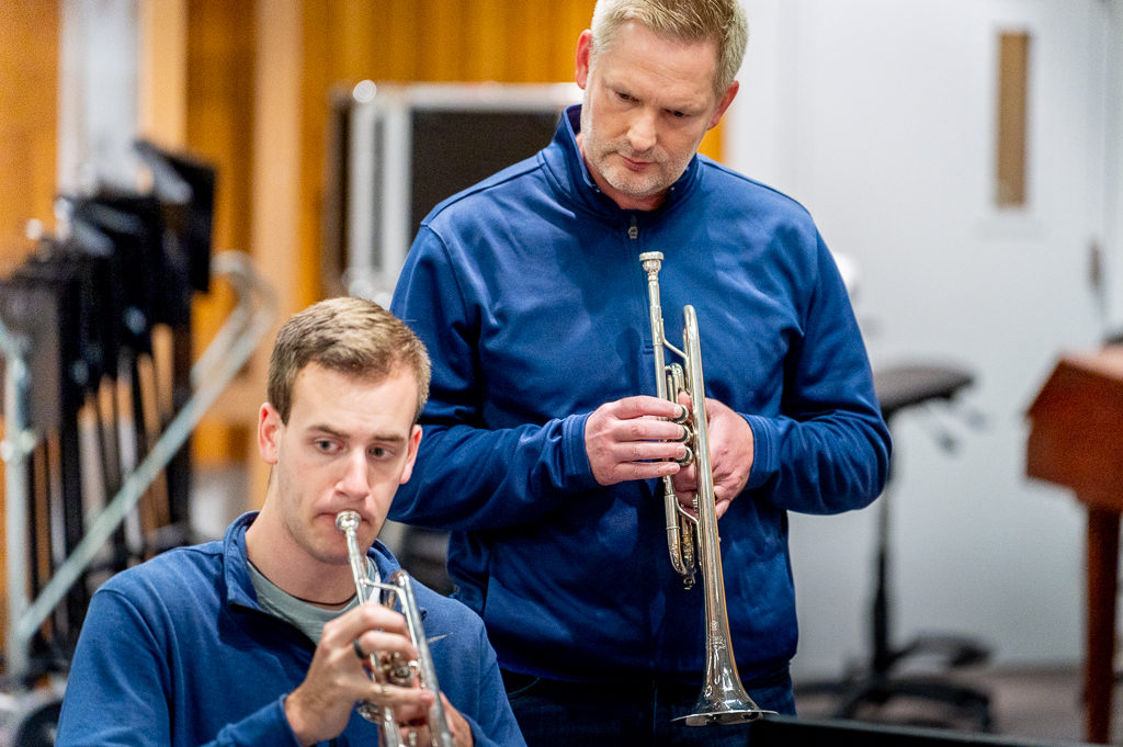 A trumpet student and teacher work together.