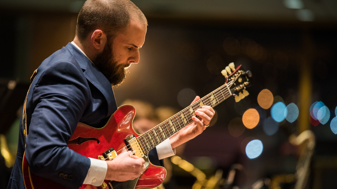 A student performs on guitar.