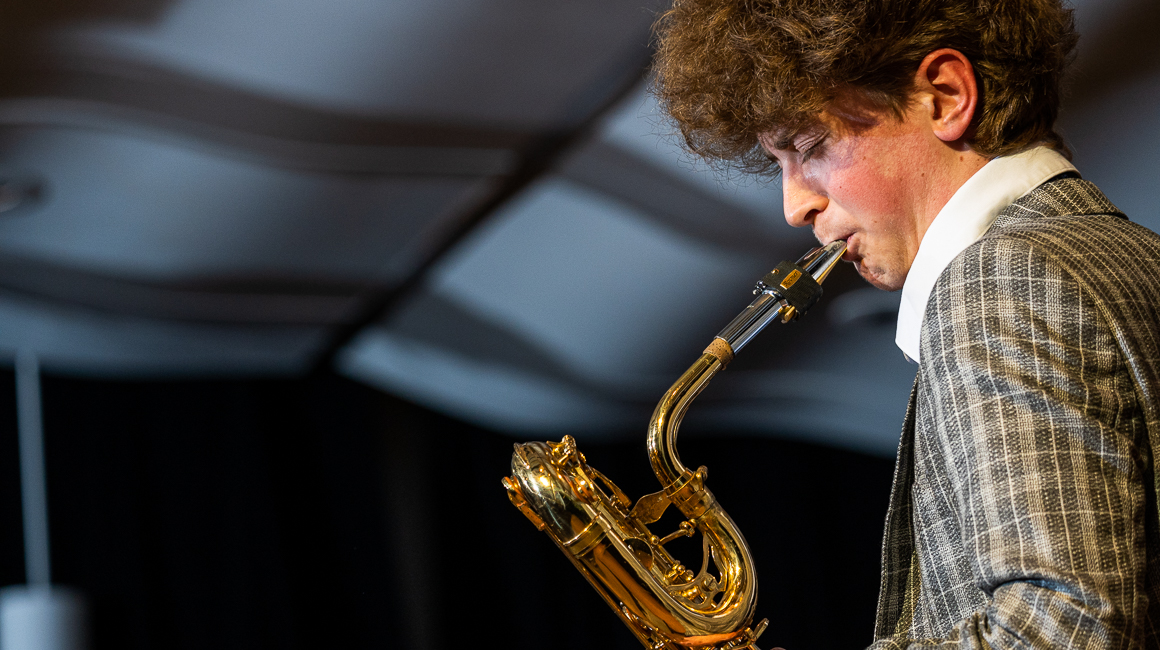 A student plays a baritone saxophone.