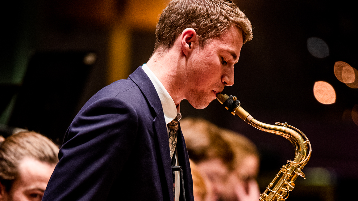 A young man plays saxophone.