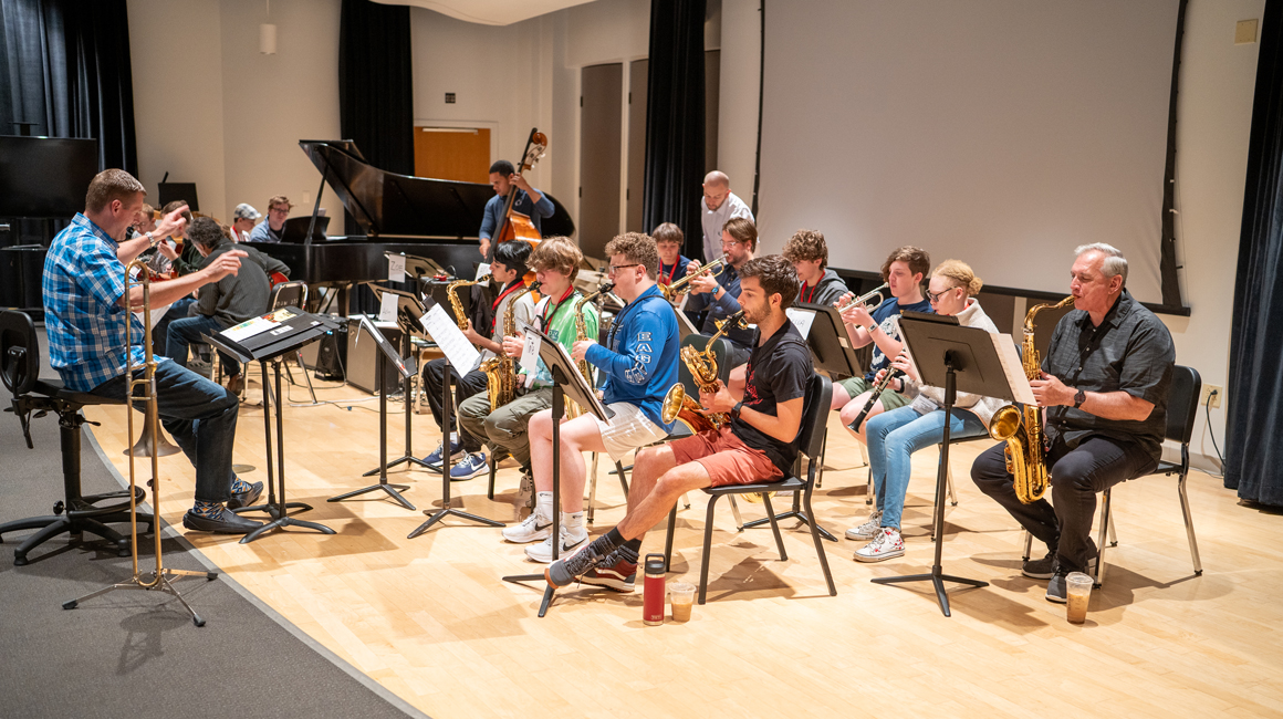 Professors and students perform together on stage.