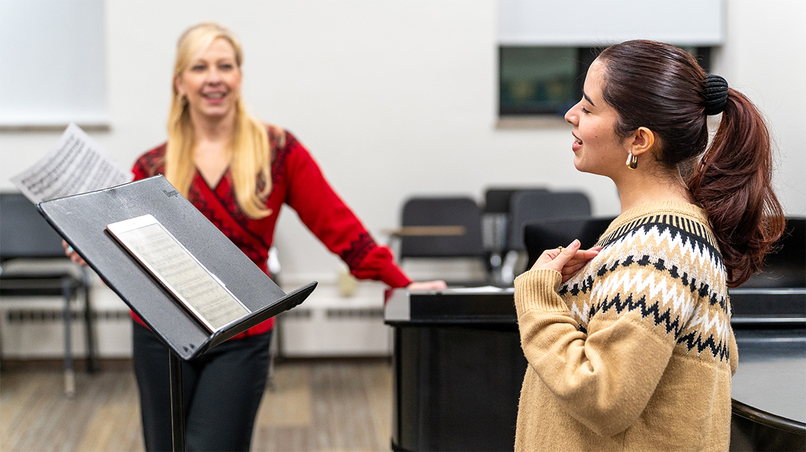 A singer and their teacher working together.