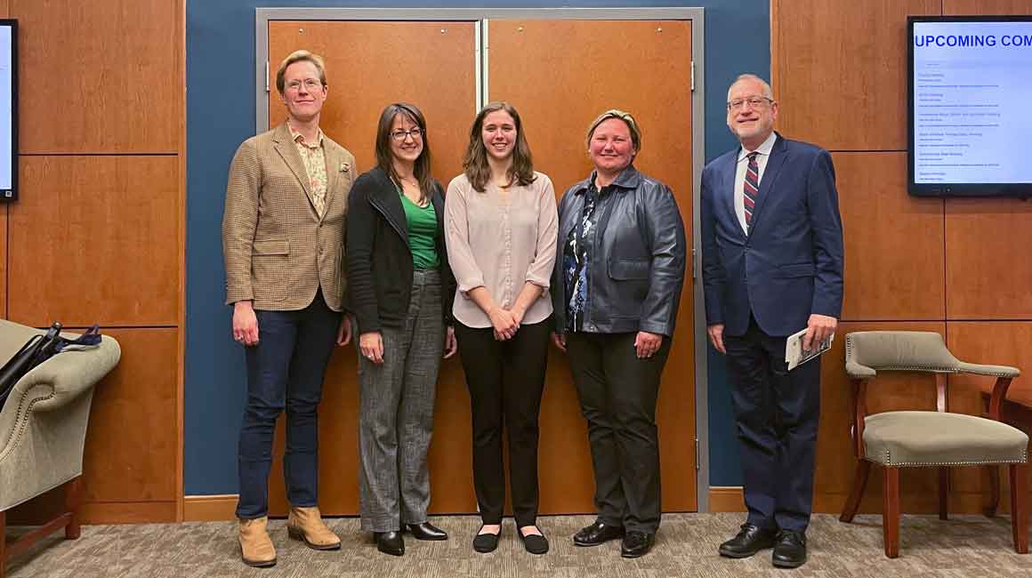 Five people pose for a photo in front of PNC Recital Hall doors.