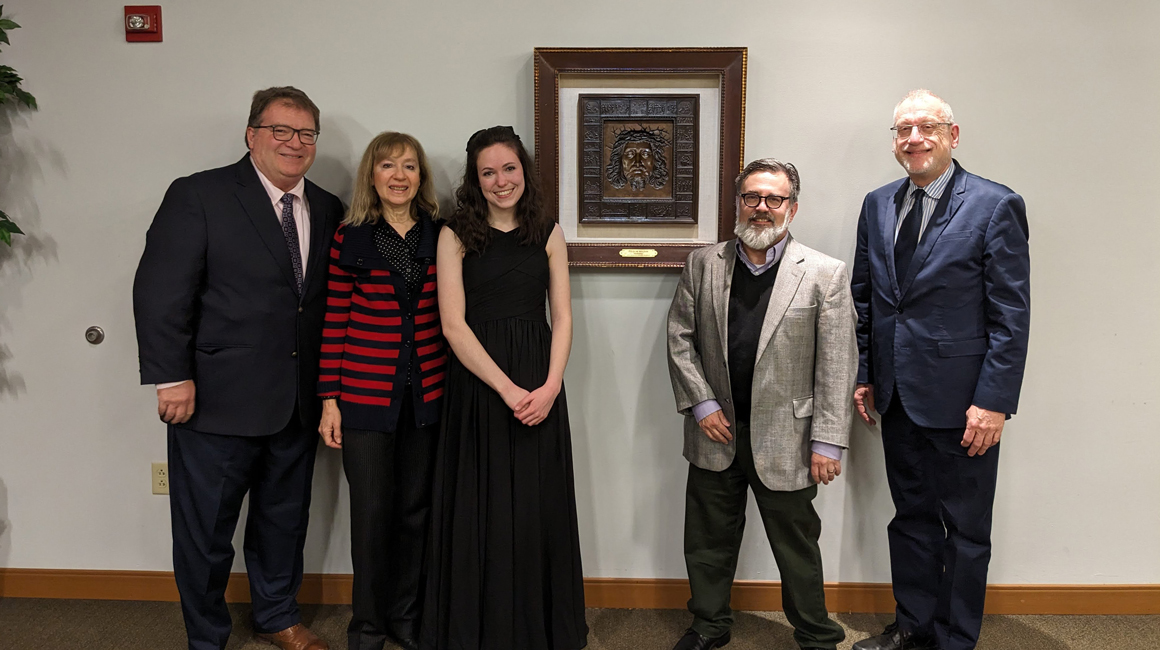 Competition winner poses with judges and Dean David Allen Wehr.