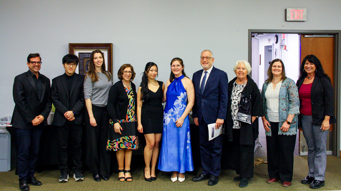 Ten people pose for a photo in the PNC Recital Hall Lobby.