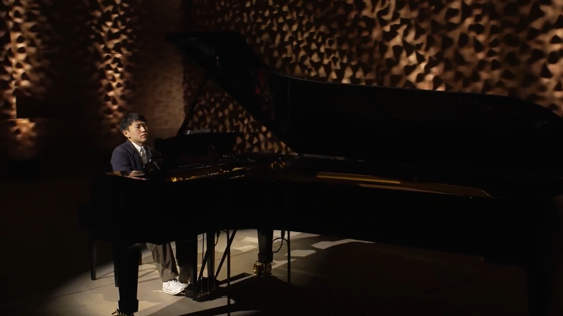 A person plays a piano on stage.