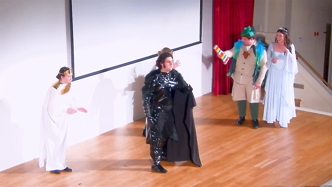 Performers in costume act and sing in a production of Mozart's The Magic Flute.