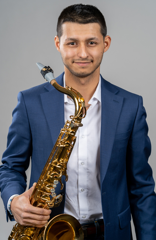 Jake McCormick smiling and holding a saxophone