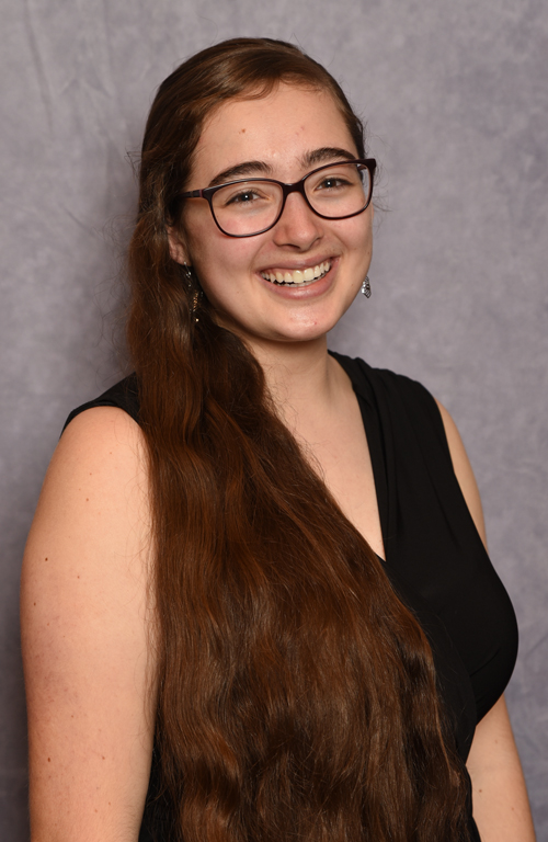 smiling woman in front of a gray background