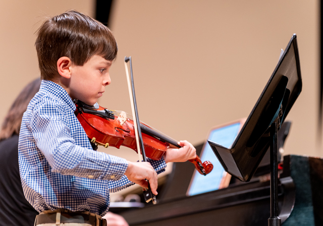 A child plays a violin.