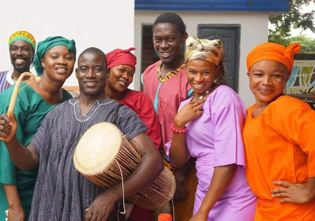 Several people pose for a photo wearing colorful clothing.