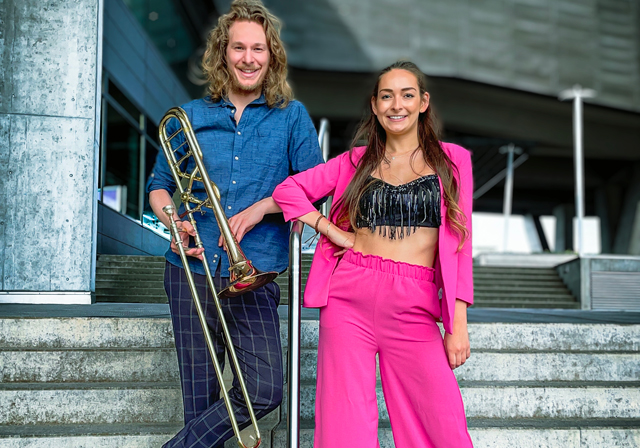 Two people pose for a photograph on a staircase.