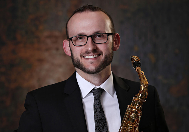 A person holds a saxophone.