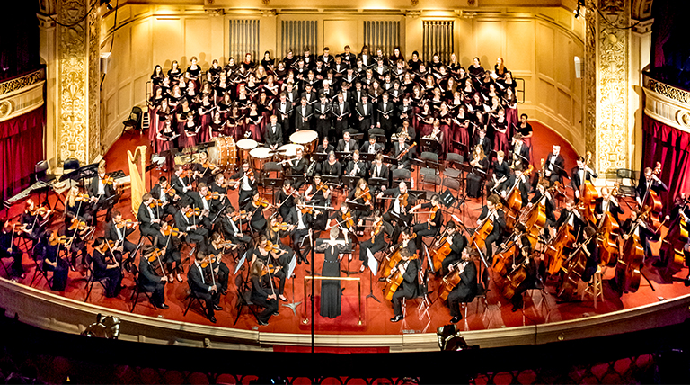 Choirs and orchestra perform on stage