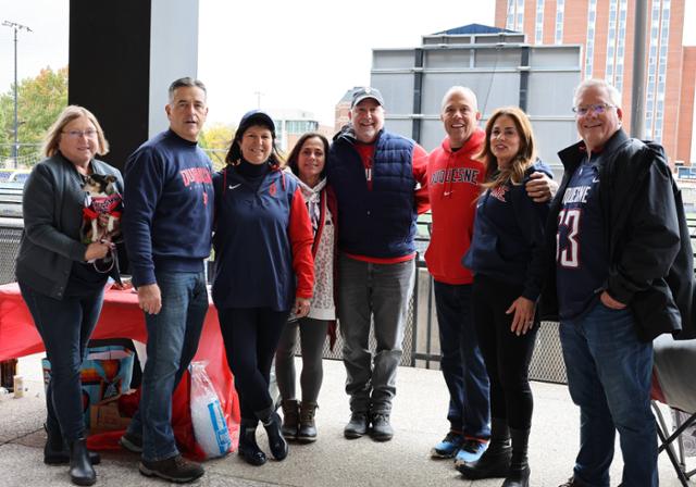 a group of people standing in front of a football field
