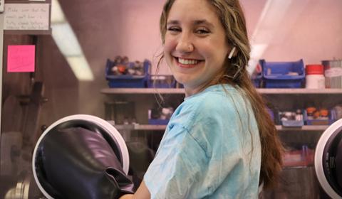 Alayna is smiling at the camera while working on her research.