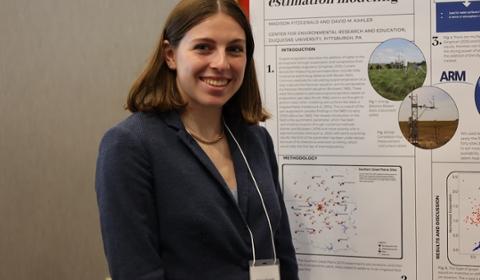 Madison stands beside her research poster presentation.