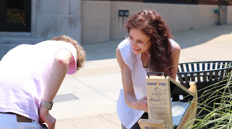 a teacher and a student looking at a sun spotter