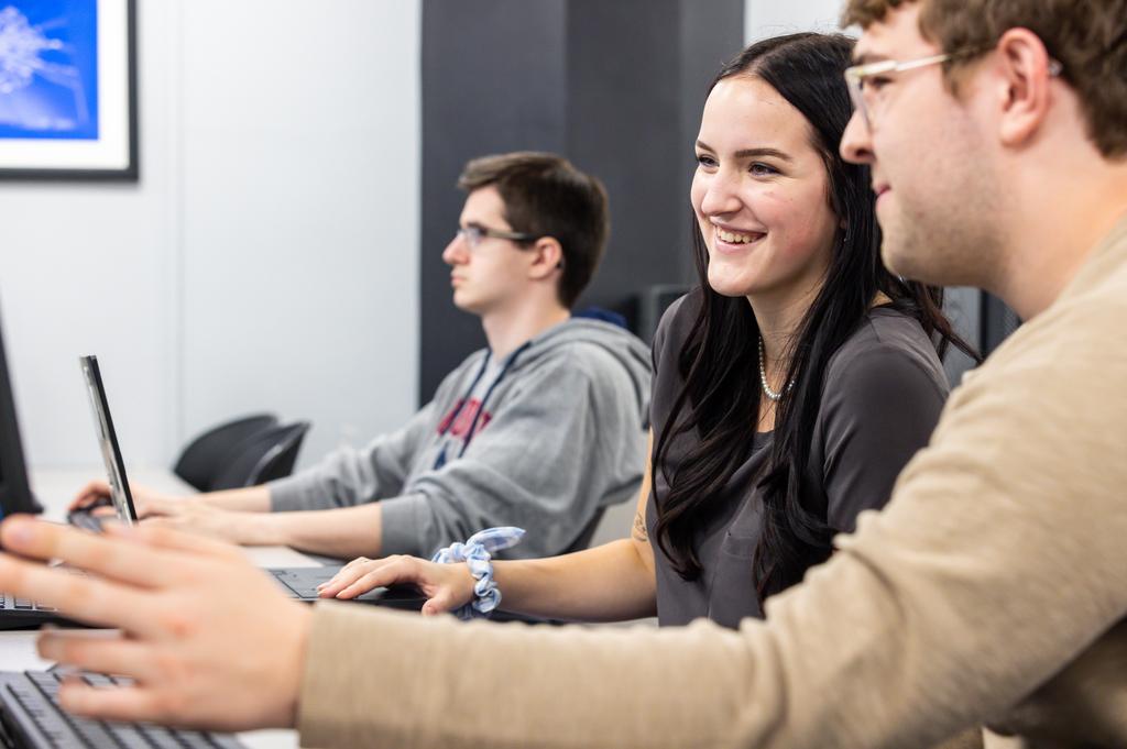 students and faculty looking at a computer