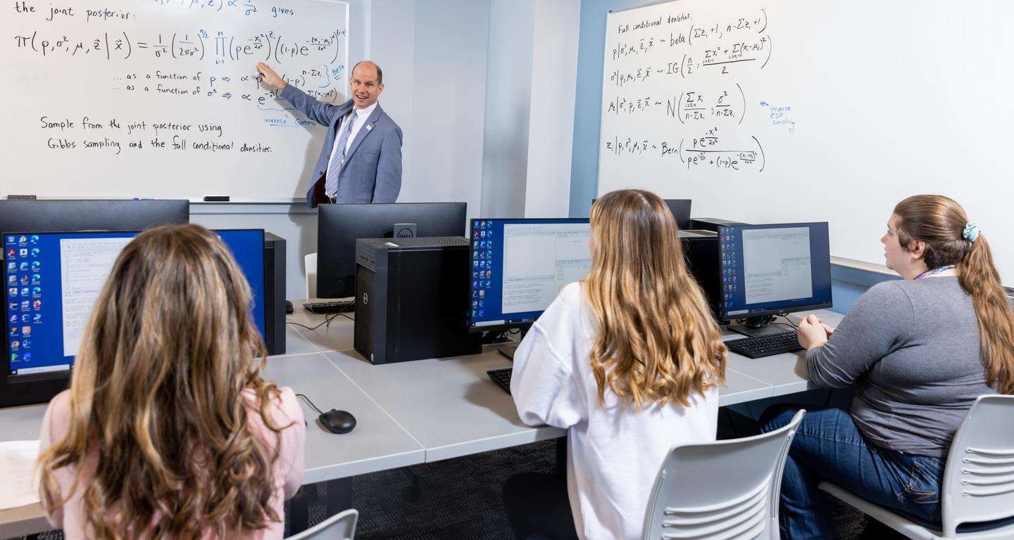a picture of a professor teaching students